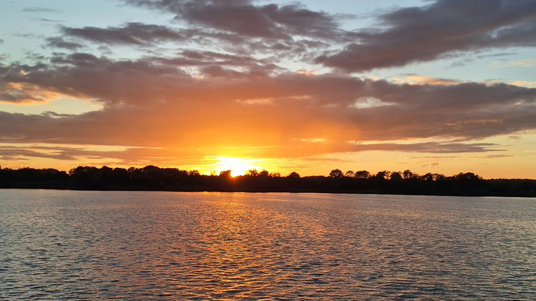Leuchtender Sonnenuntergang über der Müritz während des Mitarbeiterausflugs des Immanuel Hauses Ecktannen Leuchtender Sonnenuntergang über der Müritz während des Mitarbeiterausflugs des Immanuel Hauses Ecktannen