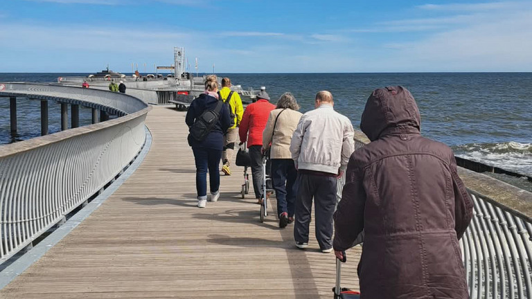 Reisegruppe auf Seebrücke unterwegs